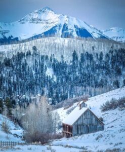 Snowy scene of mountain and a barn